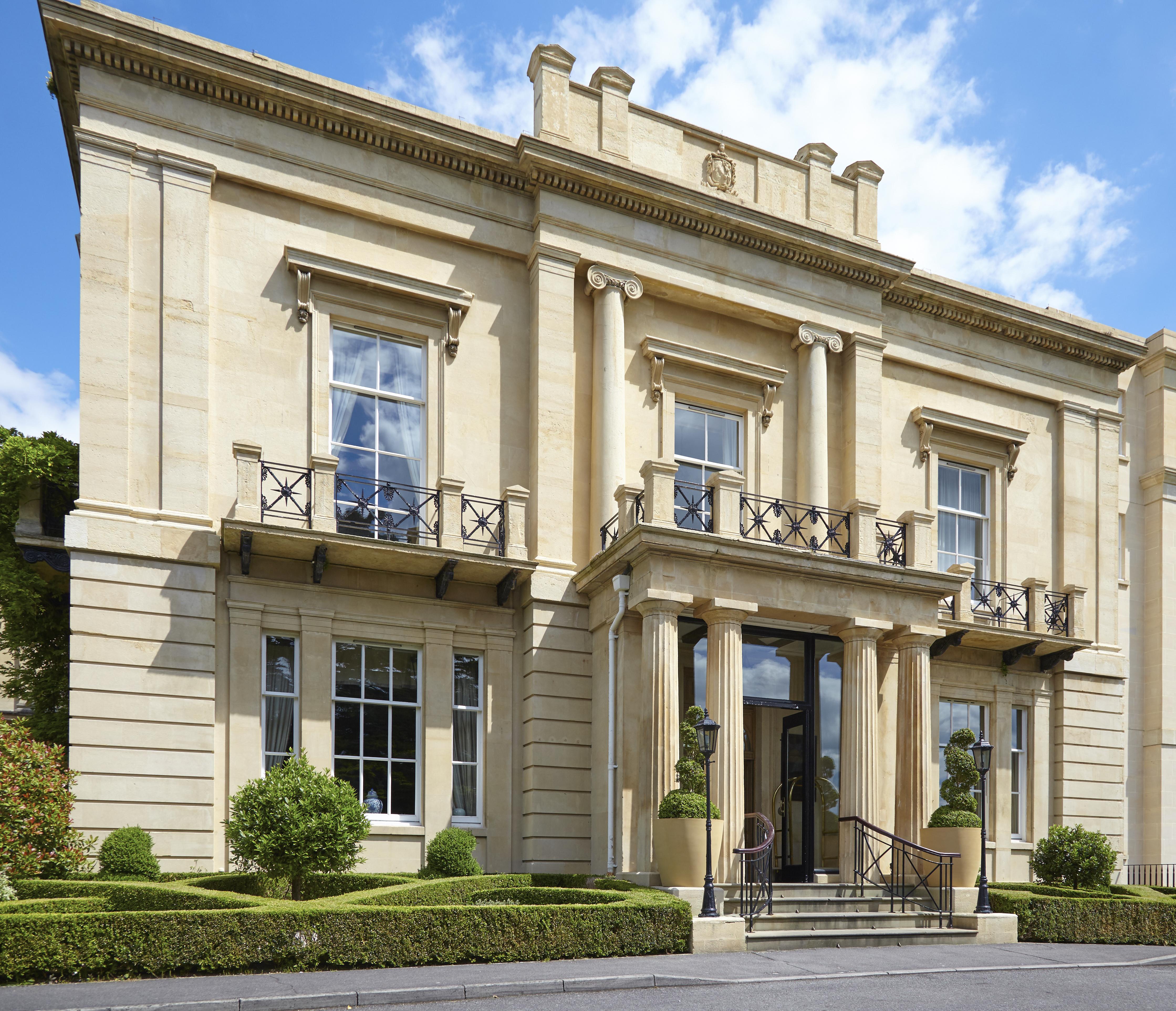 맥도날드 배스 스파 호텔 바스 외부 사진 The photo shows a large, elegant building designed in a classical architectural style. It features a symmetrical facade with tall columns and decorative details. The entrance is marked by a set of stairs leading up to double doors, flanked by windows